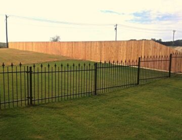 Black iron final fence in the middle of landscaped grass