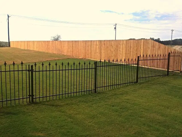Black iron final fence in the middle of landscaped grass